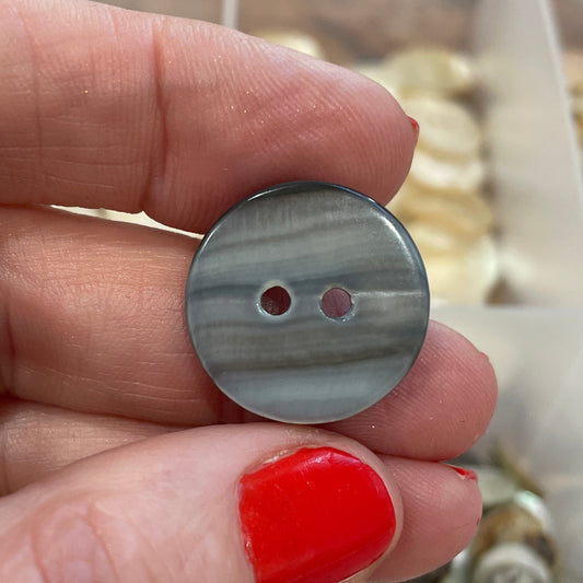 Hand holding a button with a blurred background of buttons