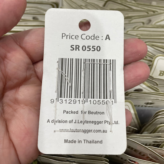 Close-up of a price tag with a barcode held by a hand, with more tags in the background.