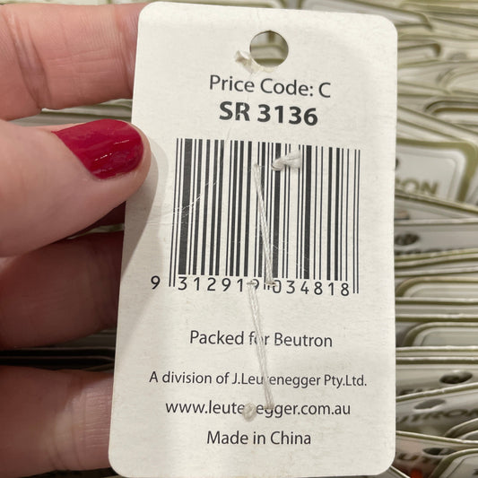 Close-up of a product tag with a barcode held by a hand.