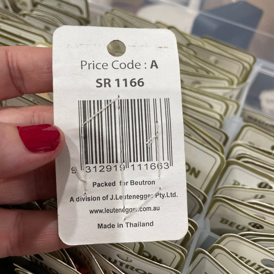 Close-up of a price tag with a barcode held by a hand against a background of similar tags.