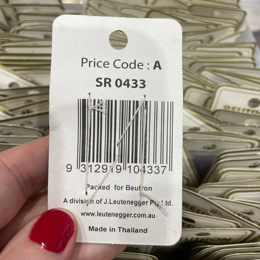Close-up of a price tag with a barcode held by a hand with red nail polish.