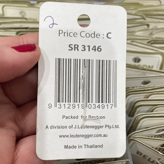 Close-up of a product tag with a barcode and text, held by a hand.