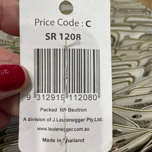 Close-up of a price tag with a barcode and text, held by a hand with red nail polish.