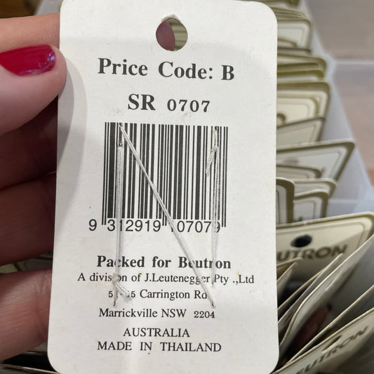 Close-up of a product tag with text and barcode, held by a hand.