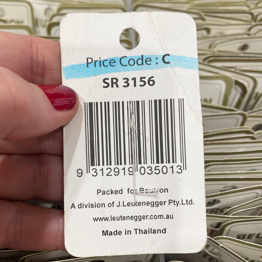 Close-up of a product tag with a barcode held by a hand, surrounded by more tags in the background.