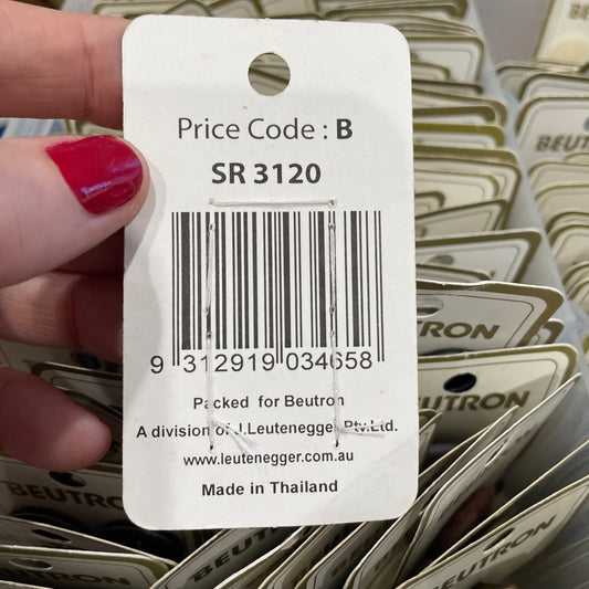 Close-up of a price tag with a barcode held by a hand, with more price tags in the background.