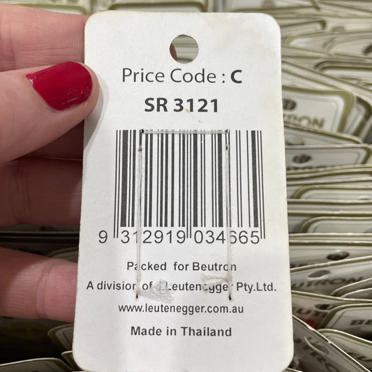 Close-up of a product tag with a barcode held by a hand.