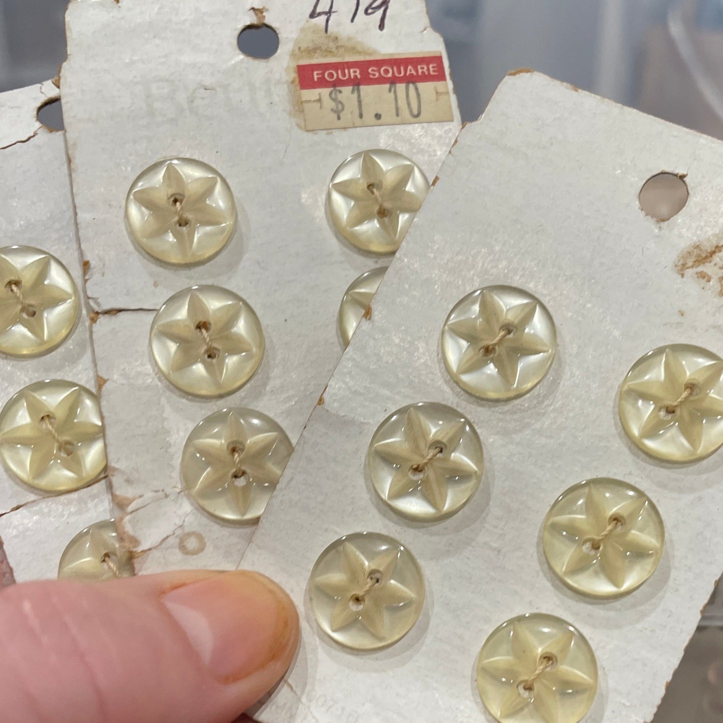 Hand holding a card with gold buttons on a blurred background