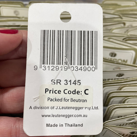 Close-up of a product tag with a barcode and text, held by a hand.