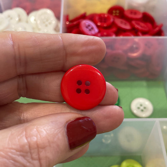 Hand holding a red button with a background of colorful buttons in containers