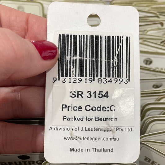 Close-up of a price tag with a barcode held by a hand, surrounded by more price tags.