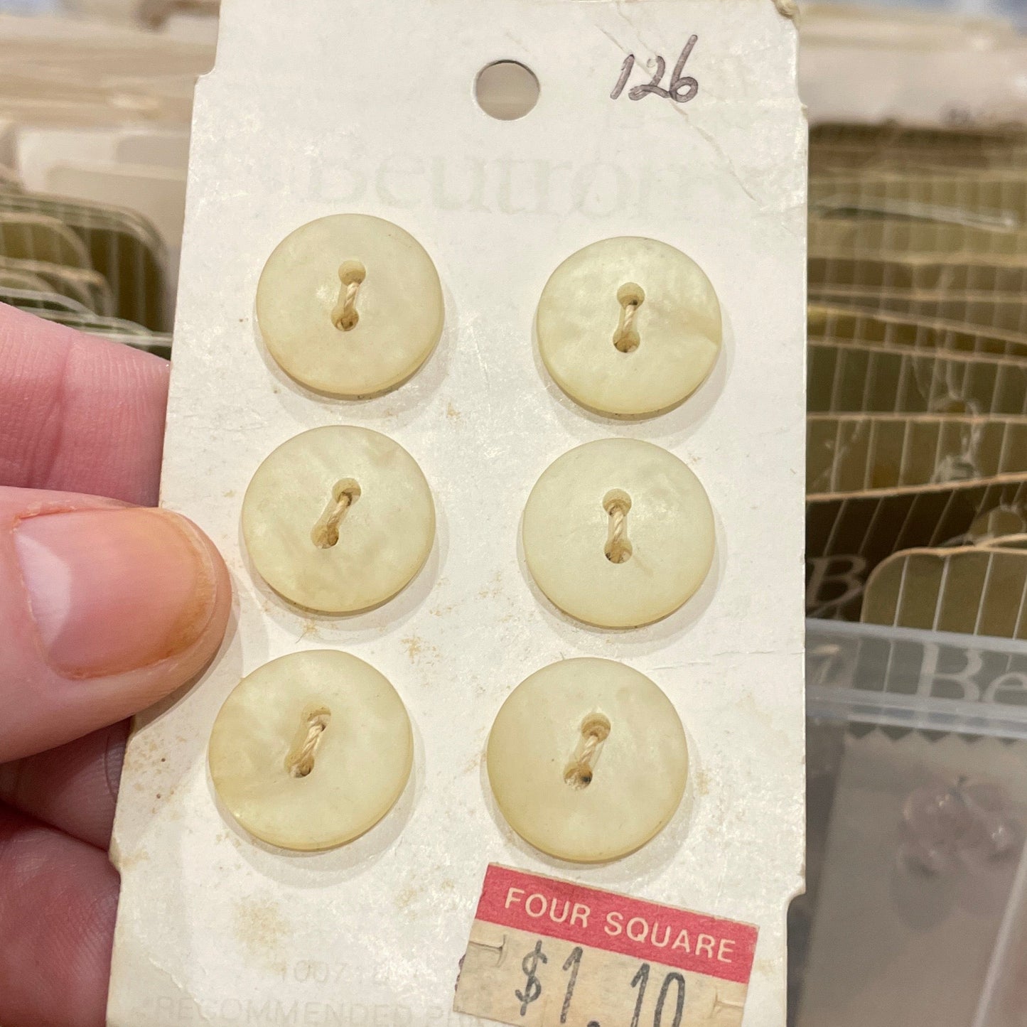 Set of vintage buttons on a card held by a hand with a blurred background