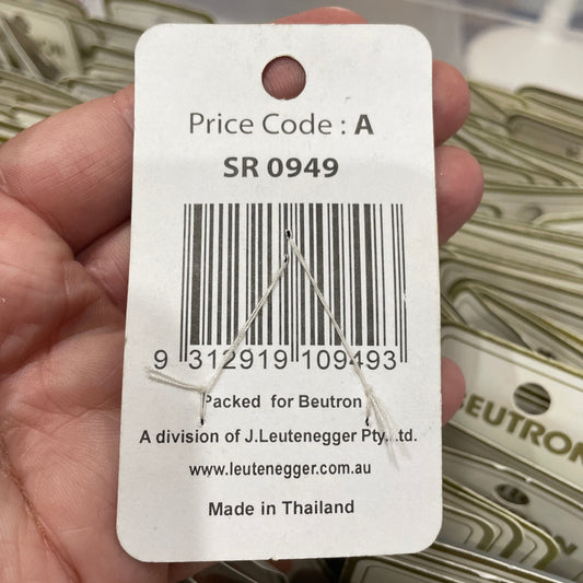 Hand holding a price tag with a barcode and product details, with a blurred background of similar tags.