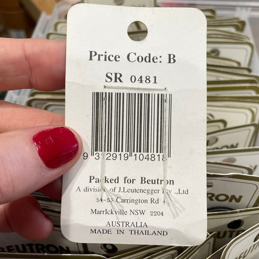 Hand holding a price tag with a barcode and text, surrounded by similar tags.