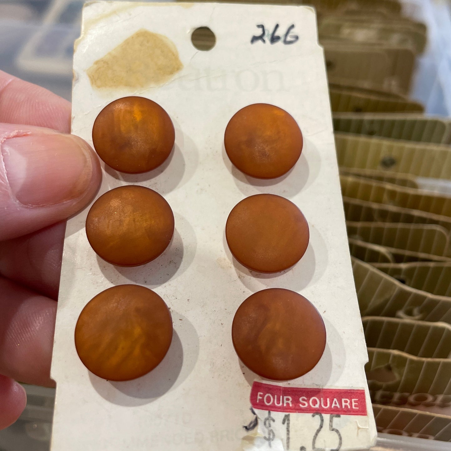 Set of buttons on a card held by a hand with a blurred background