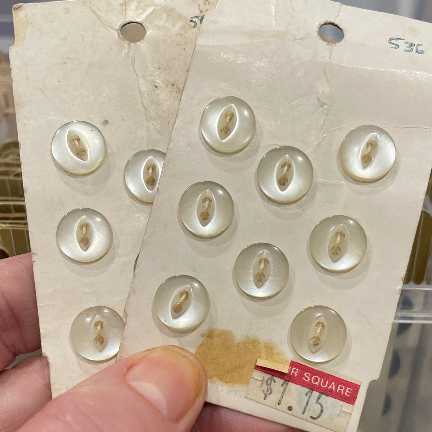 Hand holding a card with buttons against a blurred background