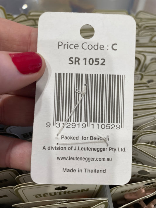 Close-up of a price tag with a barcode and text, held by a hand with red nail polish.