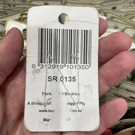 Hand holding a product tag with a barcode and text