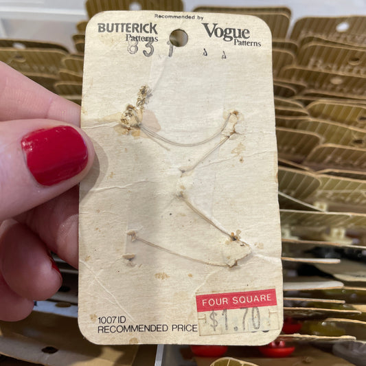 Card with floral design held by a hand with red nail polish.