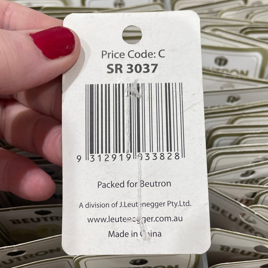 Hand holding a Beutron label with a barcode and text.