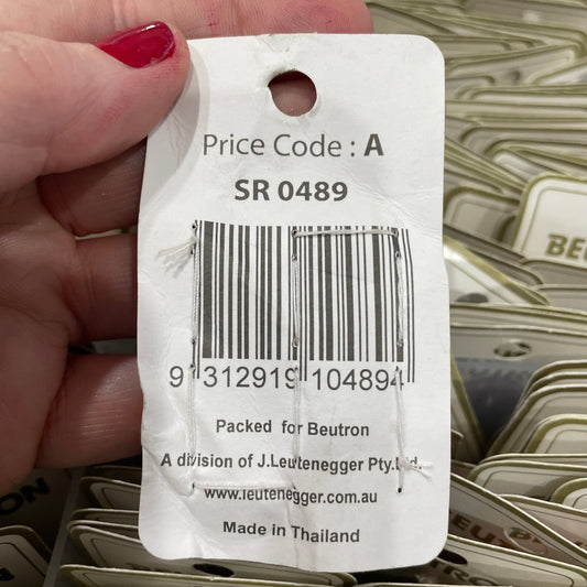 Close-up of a price tag with a barcode held by a hand.