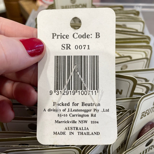 Hand holding a Beutron price tag with a barcode and text