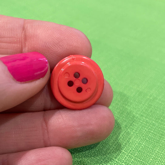 Hand holding a red button against a green background