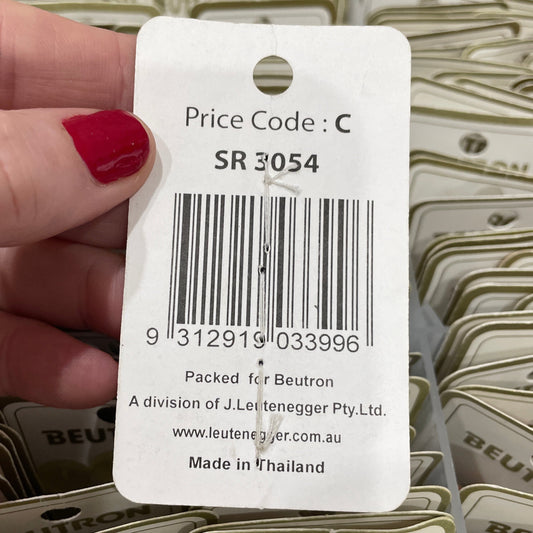 Hand holding a price tag with a barcode and product details, surrounded by similar tags.