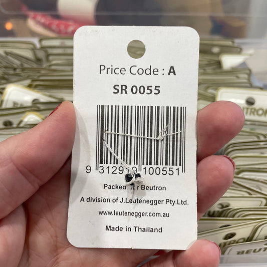 Hand holding a product tag with a barcode and text