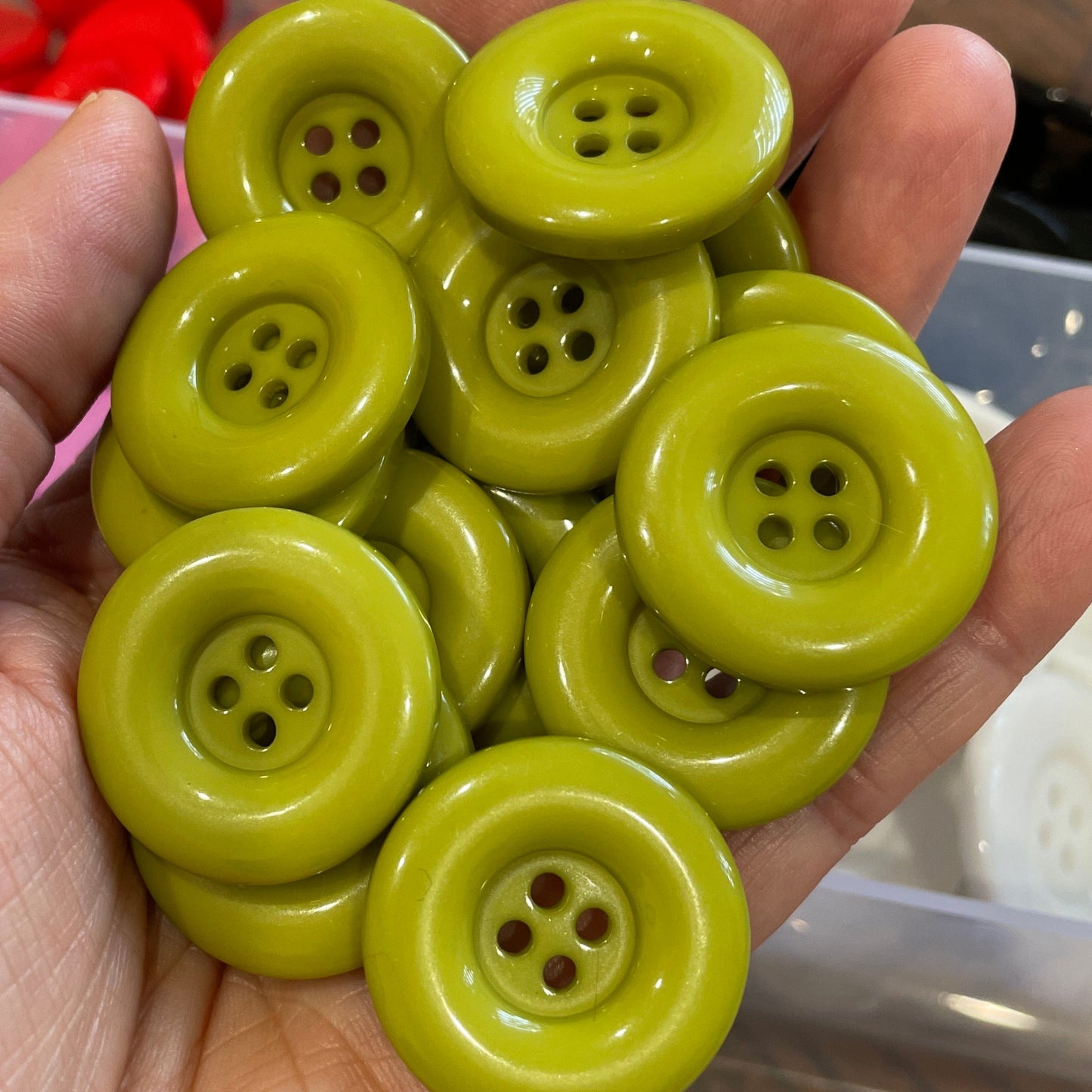 Hand holding a cluster of green buttons with a blurred background