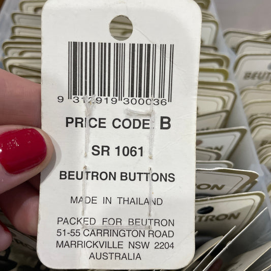 Close-up of a Beutron button tag with a barcode and text details.