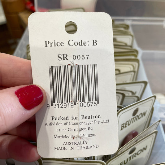 Close-up of a price tag with a barcode held by a hand with red nail polish.