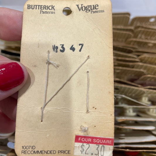 Card held by a hand, with a blurred background of patterned fabric.