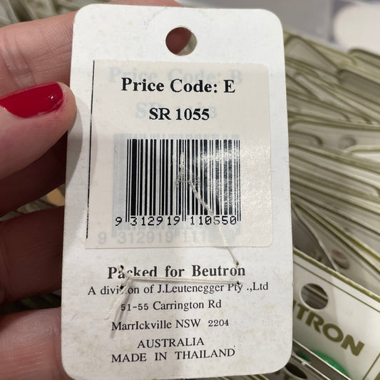 Close-up of a product tag with a barcode and text, held by a hand.
