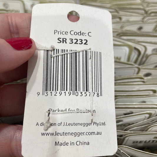 Close-up of a product tag with a barcode held by a hand.