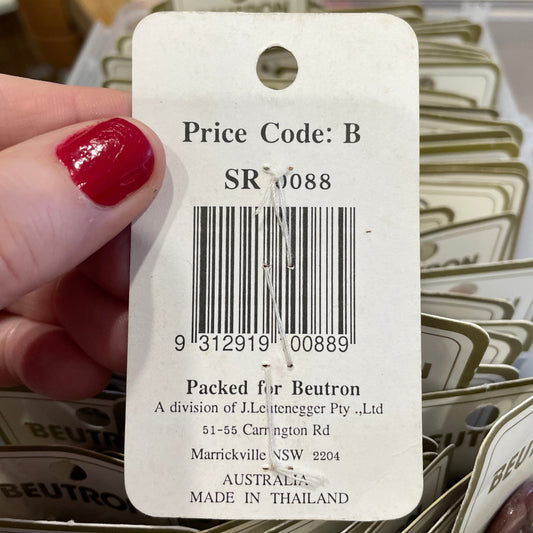 Close-up of a price tag with a barcode held by a hand, with more tags in the background.