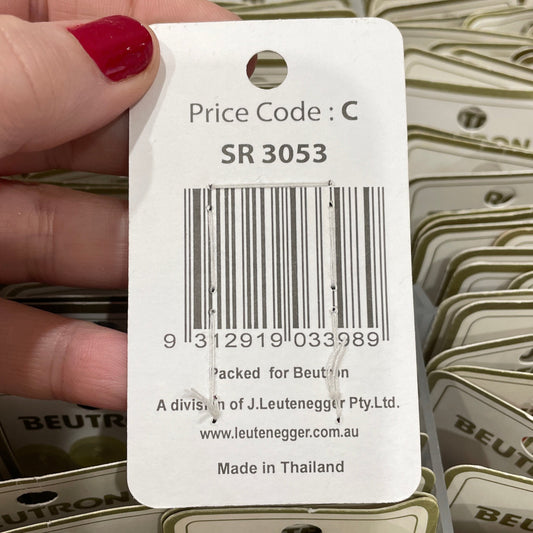 Hand holding a Beutron brand tag with a barcode and text, against a background of similar tags.