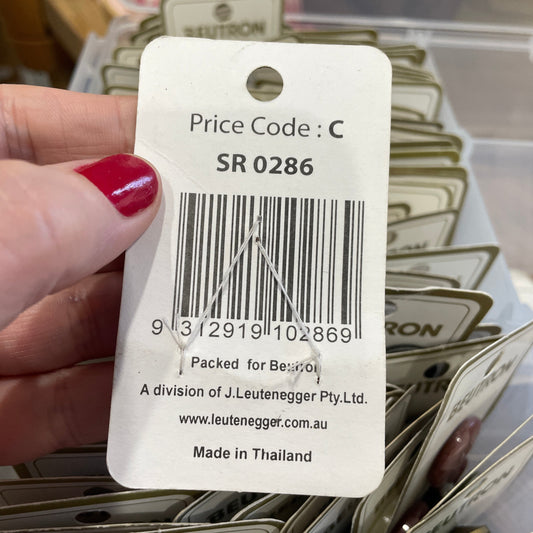 Close-up of a price tag with a barcode held by a hand.