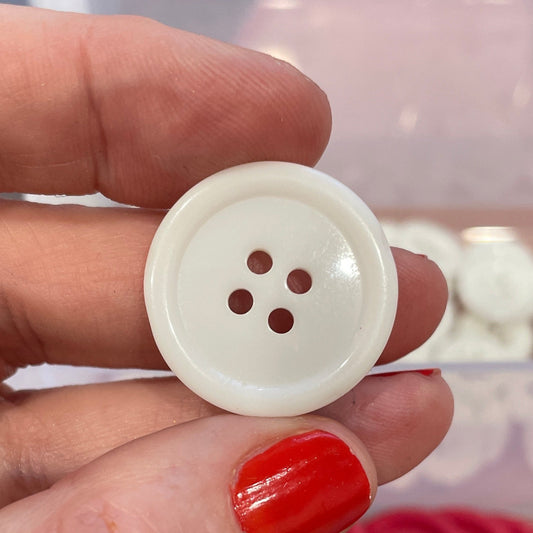 Hand holding a white button with red buttons in the background