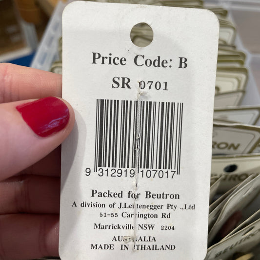 Close-up of a price tag with a barcode held by a hand.