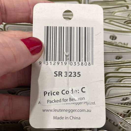 Hand holding a price tag with a barcode and text, surrounded by more price tags.