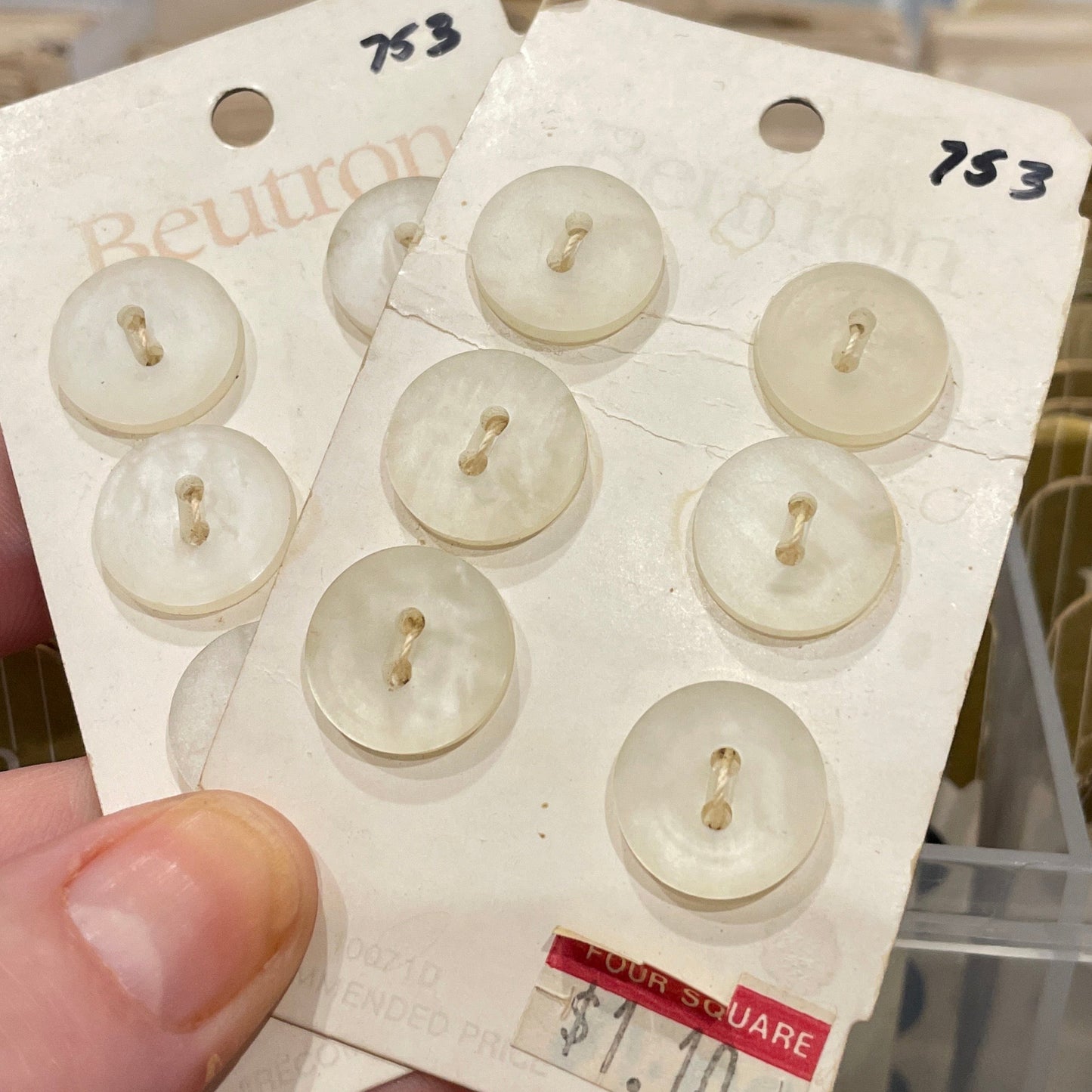 Card with six buttons held by a hand in front of a blurred background