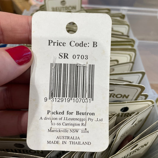 Close-up of a price tag with a barcode held by a hand.