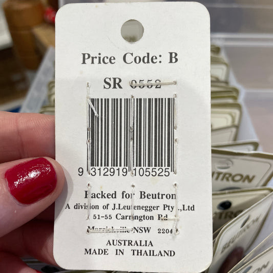 Close-up of a product tag with a barcode held by a hand.