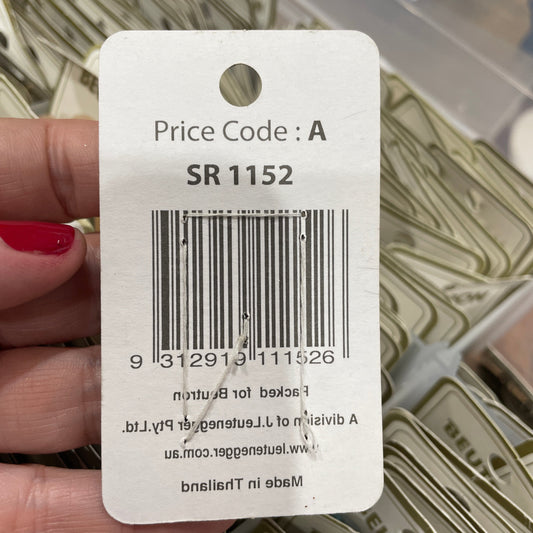 Barcode label held by a hand with red nail polish on a blurred background