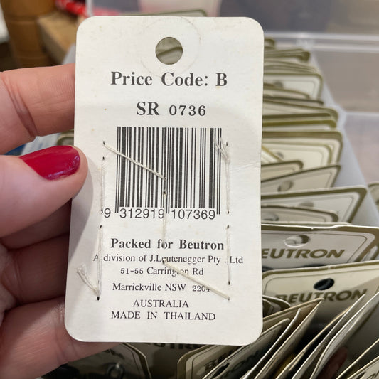 Hand holding a Neuton price tag with a barcode and product details.