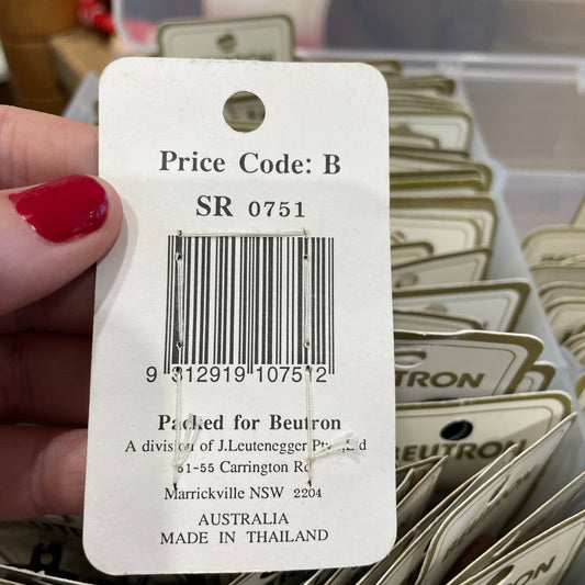 Close-up of a price tag with a barcode held by a hand, with blurred background