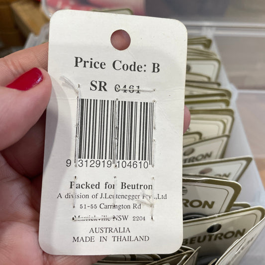 Close-up of a price tag with a barcode held by a hand.