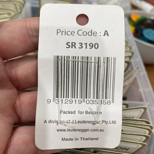 Price tag with barcode and text held by a hand, with a blurred background