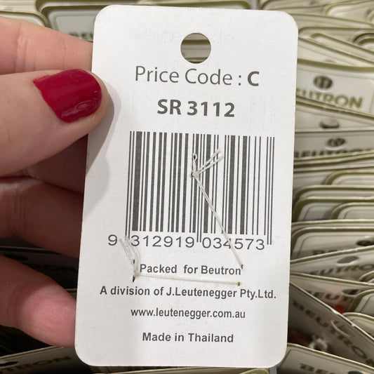 Close-up of a price tag with a barcode held by a hand against a background of similar tags.